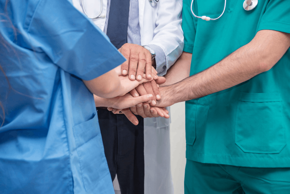 Doctor and nurses holding hands together