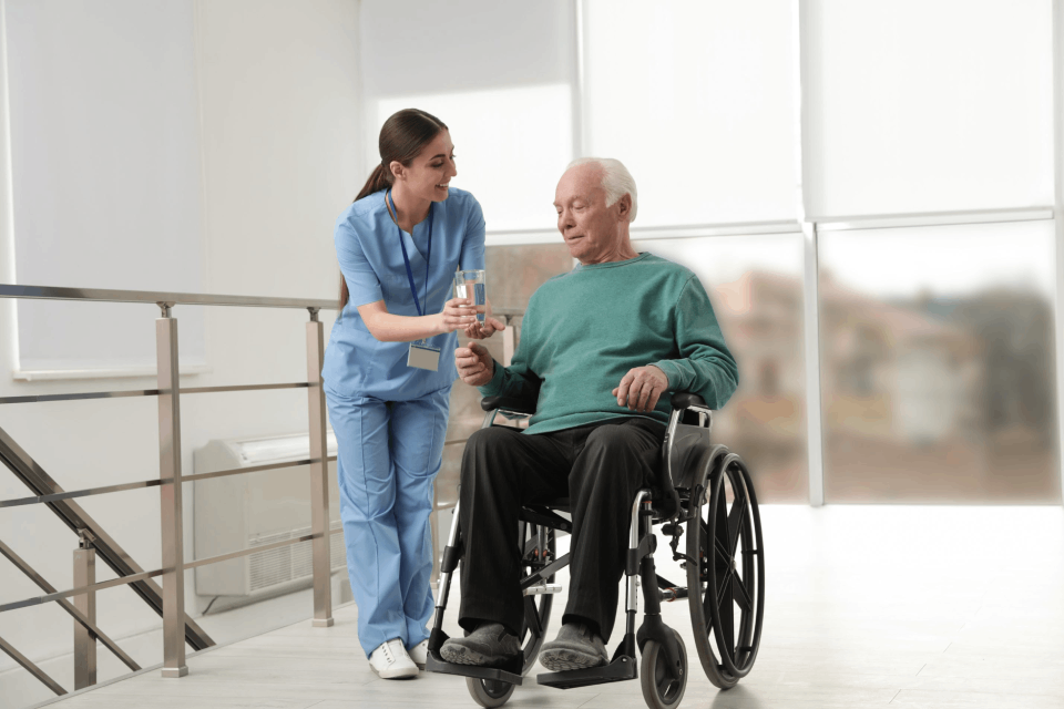 Nurse serving elderly patient on wheelchair