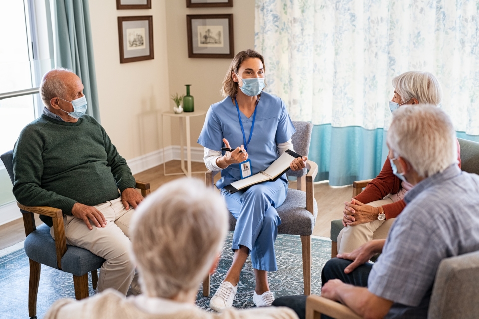 Nurse with elderly people around her